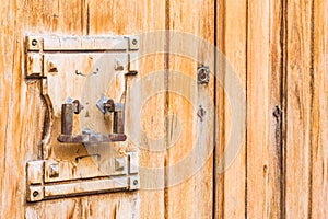 Old door knocker on rustic wood front door, close-up