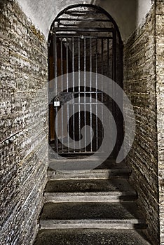 Old door made of steel grating in the stone wall