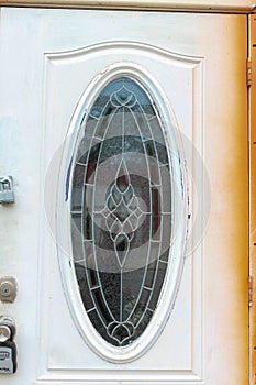 An old door with an oval leaded glass window