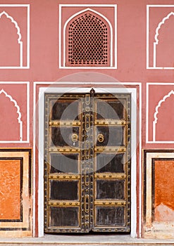 Old door in palace with pink walls in Jaipur, India