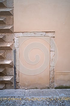 Old door walled up with cement and stones in a weathered old stone wall