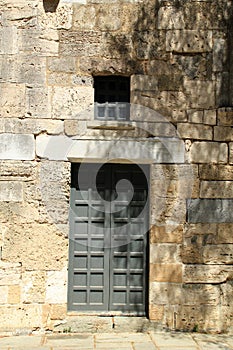 Old door and window in ancient stone wall in Greece