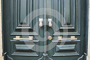 Old doorknocker with hand shape on old wooden door