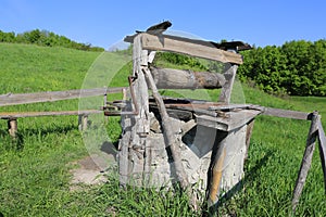 Old draw well on green meadow