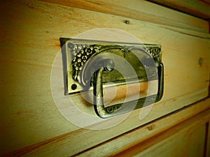 Old drawer handle with floral ornament closeup photo