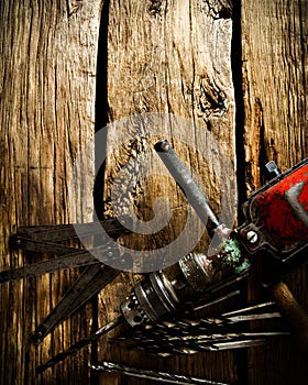 Old drill, ruler and drills on wooden background