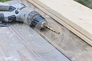 Old drill on wooden planks