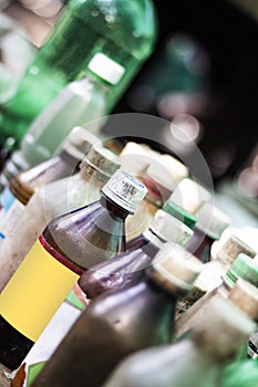 An old drugstore has many small bottles of medicine in a row and the background blur