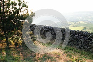 Old dry stone wall in welsh countryside, mountains in background