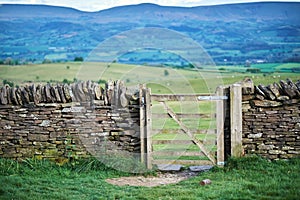 Old dry stone wall in welsh countryside, mountains in background