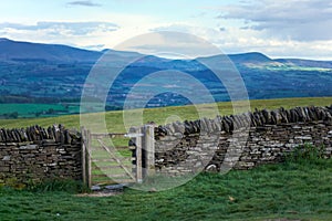 Old dry stone wall in welsh countryside, mountains in background