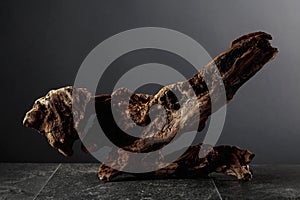 Old dry wooden snag on a black stone table