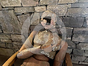 Old dummy doll on the background of stone wall with a hole on its face