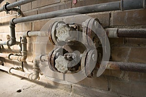 Old dusty open close valve on yellow brick wall