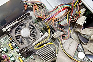 Old dusty pc motherboard with cables and fan