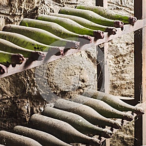 Old dusty wine bottles in cellar - square composition