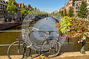 Old Dutch bike against the railing of a bridge over a canal in Amsterdam, Holland