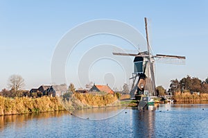 Old Dutch windmill at the edge of a small river