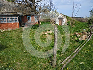 Old earth cold cellar built into a hill beside a house