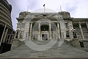 Old Edwardian parliament in grey stone with classic colonnade entry on grand stairs, Wellington, New Zealand