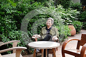 Old elder woman resting in park. elderly female relaxing outdoors. senior leisure lifestyle
