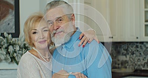 Old elderly adult family couple hugging bonding looking at camera, smiling healthy senior retired grandparents, close up