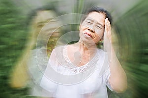 Old elderly Asian feeling faint and dizzy from hot weather photo