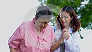 An old elderly Asian woman Do physical therapy and walking in the garden with her doctor. Concept of happy retirement With care