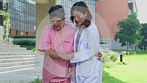 An old elderly Asian woman Do physical therapy and walking in the garden with her doctor. Concept of happy retirement With care