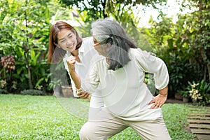 An old elderly Asian woman and exercise in the backyard with her daughter.  Concept of happy retirement With care from a caregiver