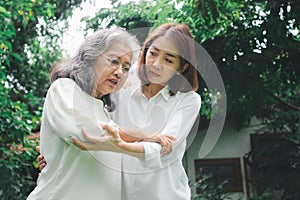 An old elderly Asian woman and walking in the backyard with her daughter.  Concept of happy retirement With care from a caregiver