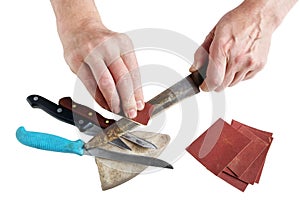 Old elderly master tries to sharpen rusty kitchen knives - isol