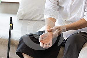 Old elderly people with wrist injury,bone pain in wrist,numbness or beriberi,asian senior woman suffering from De quervain`s photo