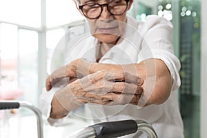 Old elderly scratching arm elbow itchy skin,skin irritation,atopic dermatitis or disorders of nerves and the nervous system, photo