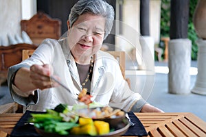 Old elderly senior elder woman eating food. mature retirement lifestyle