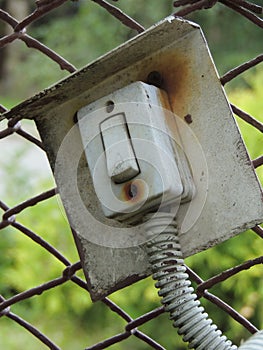 Old electric bell button on the fence