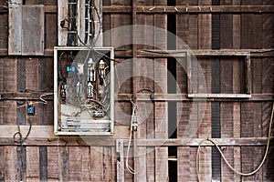 Old electric breaker box on wooden plank wall