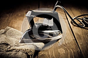 Old electric iron on the wooden background