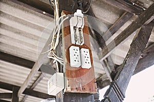 Old electric switching power breaker and AC outlet plugs on the wood board