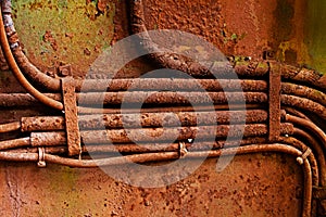 Old electrical cables on dirty rusty iron wall