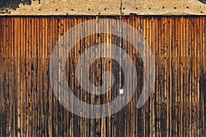 Old electrical light switch and cable on worn wooden shed exterior wall