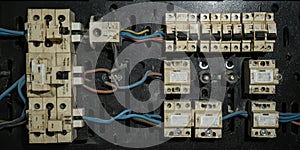 Old electrical panel with tangled wiring and circuit breakers