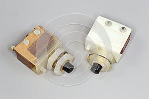 Old electrical push button switches on a gray background