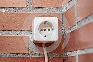 Old electrical socket on a brick wall