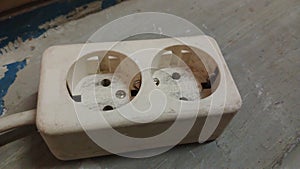 Old electrical socket isolated on gray work floor. Industrial work requires electrical power.