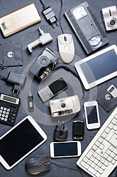 Old electronic devices on a dark background. The concept of recycling and disposal of electronic waste.