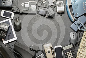 Old electronic devices on a dark background. The concept of recycling and disposal of electronic waste. Copy space