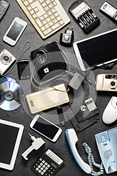 Old electronic devices on a dark background. The concept of recycling and disposal of electronic waste.
