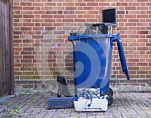 Old electronic equipment dumped in a recycling bin.