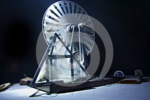 Old electrostatic machine, Wimshurst generator and glass pyramid on black background. Physics education concept